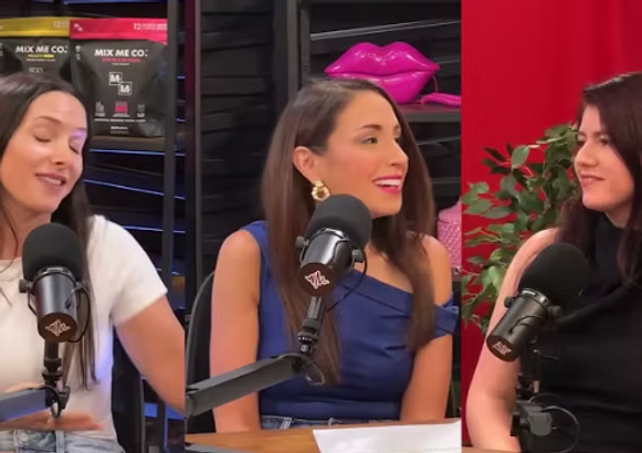 Three women sitting at a table with microphones, likely in a podcast or interview setting.